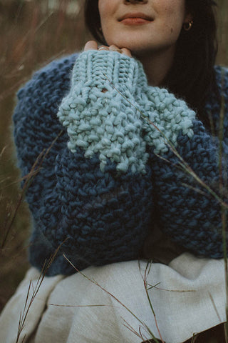 Woman wearing blue chunky knit merino wool Cutie Sweater by Toast & Yarn. 