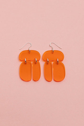 Translucent orange Ovoid Trio acrylic earrings by Warren Steven Scott. 